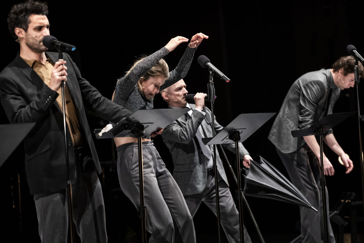 group of performers on a dark stage