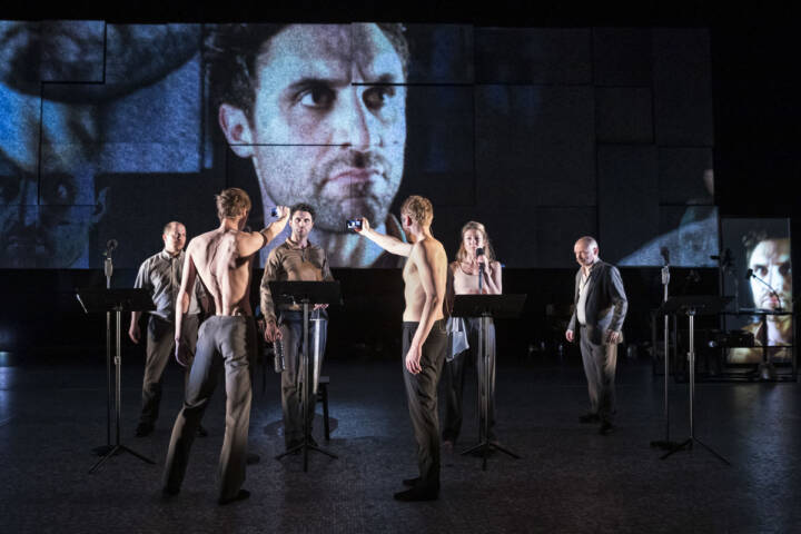 performers on stage with a video projection backdrop