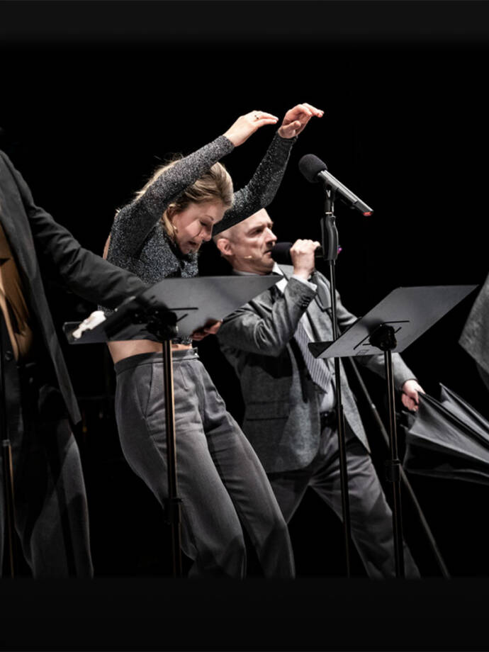 group of performers on a dark stage