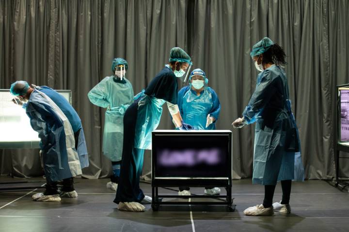 actors dressed in hospital scrubs on stage