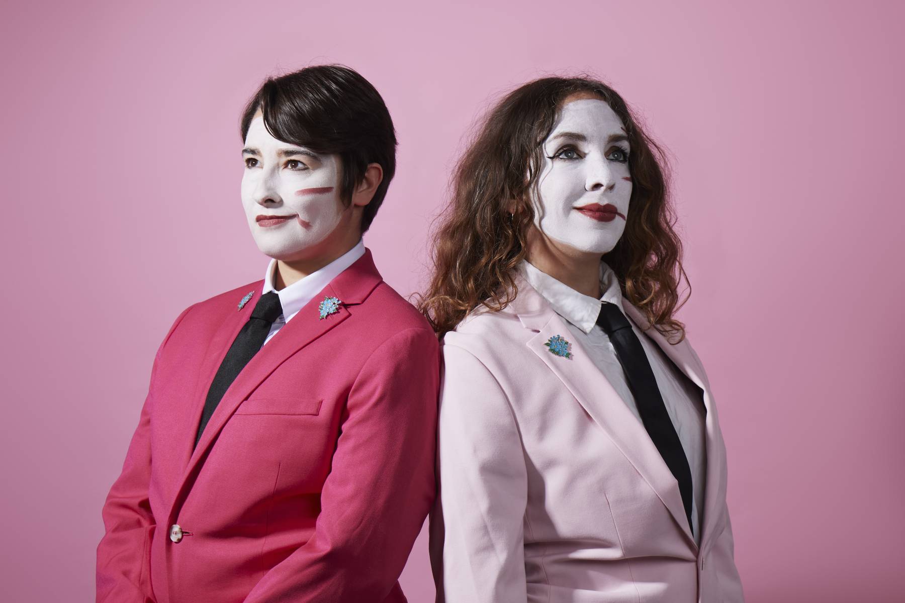 two women in white face paint and pink jackets